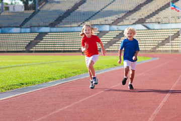 Child running in stadium. Kids run. Healthy sport.