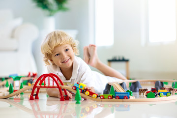 Kids play wooden railway. Child with toy train.