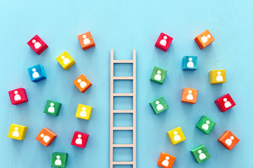 Business image of wooden ladder with people icons over blue table, human resources and management...