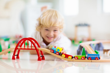 Kids play wooden railway. Child with toy train.