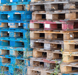 Old wooden pallets from cargo, shipping. Discarded, stacked.