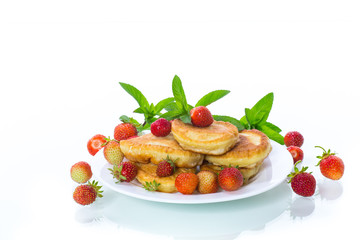 fried sweet pancakes with ripe strawberries in a plate