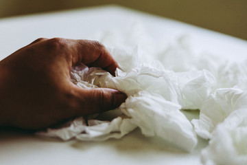 Fototapeta na wymiar Close-up hand holding white paper tissue background.