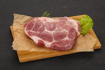 Raw pork steak over wooden board