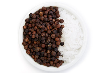 Bowl of black pepper with salt on white