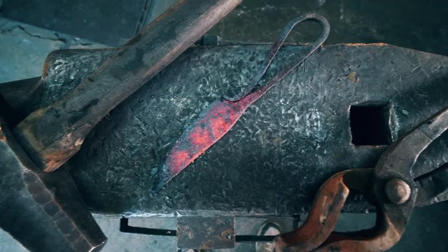 Metal tools lying on a big anvil at a forge.