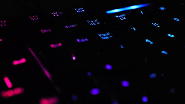 Close-up pictures on the gamer keyboard Bright red, pink, purple, green 4K light motion.
