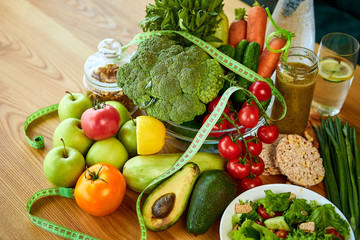 Diet weight loss breakfast concept with tape measure, organic fruits , vegetables, salad and fresh water. Healthy nutrition concept, Lifestyle and Eating