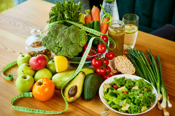 Diet weight loss breakfast concept with tape measure, organic fruits , vegetables, salad and fresh water. Healthy nutrition concept, Lifestyle and Eating