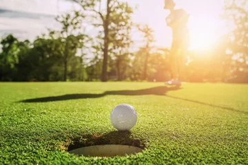 Foto op Aluminium golf player putting golf ball into hole © lovelyday12