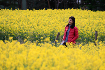 A woman feeling happy and admiring the beauty of canola field