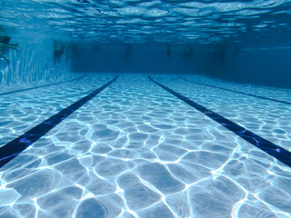 People diving in a swiming pool. Underwater view.