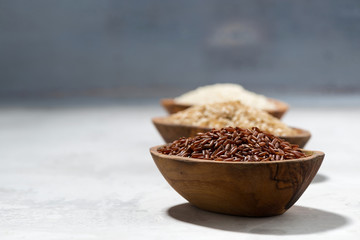 three kinds of dry rice in wooden bowls, selective focus