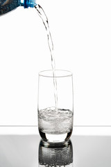 pouring water on a glass on white background