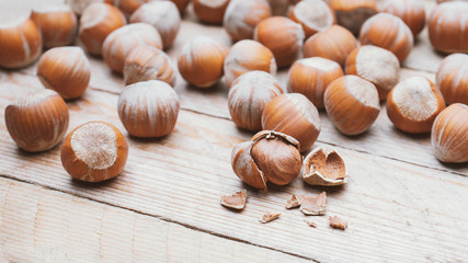 Hazelnut heap on wooden table, selective focus