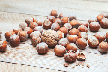 Hazelnut heap on wooden table, selective focus