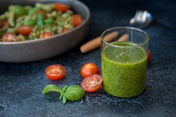 Green Basil pesto sauce on black concrete background