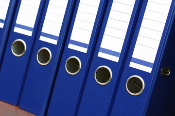 closeup of blue file binders in a row on a shelf