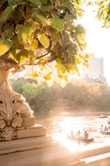 Summer in Central Park New York City seen from historic Bow Bridge with unknown people in row boats in the lake.