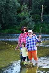 Grandfather and father with cute child boy are fishing. Family bonding. Father, son and grandfather...