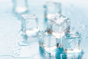 Frozen ice cube on blue background with empty space for text 