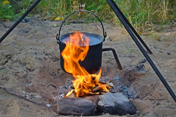 Prepare food and tea in a pot on the fire.Rest on the river Bank.
