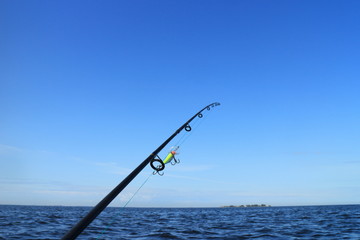 rod with fishing line stretched and crank bait fishing on the sea