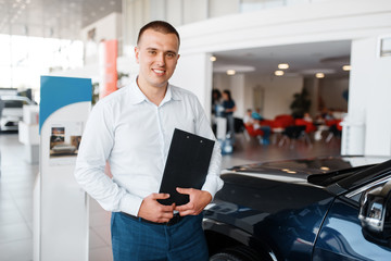 Fototapeta premium Salesman shows new car in showroom