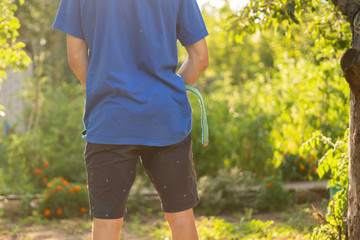 rear view of young person standing outdoor and piss under the tree