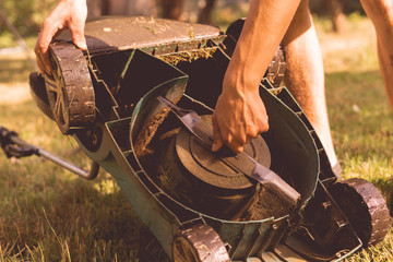 gardener repair and fix the a lawn mower in garden