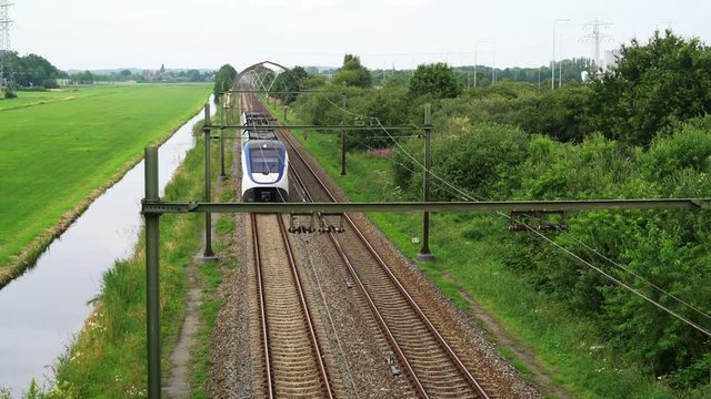 Dutch Sprinter train passes in high speed between Hilversum and Utrecht on a sunny day
