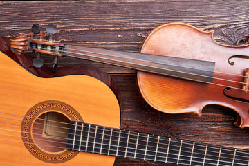 Violin and guitar on wooden background. Vintage style musical instruments.