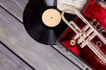 Group of musical instruments in retro style. Red velvet case with trumpet. Vinyl disc and musical...