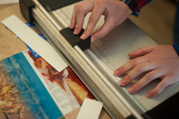 The worker cuts paper on a paper cutter