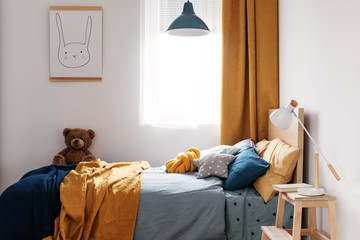 Stylish blue and orange kid's bedroom design in bright apartment