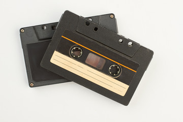 Two black cassettes on white background. Vintage audio tapes. Old-fashioned musical objects.