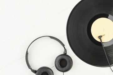 Headphones and vinyl record on white background. Vinyl disc, earphones and copy space. Outdated and...