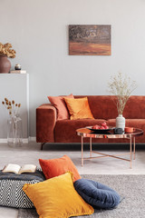 Cozy living room interior with corner sofa with pillows and painting on the wall