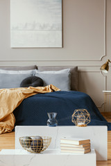 Vertical view of elegant blue, grey, gold and orange bedroom