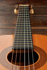 Six-strings guitar, vertical image. Acoustic guitar close up. Classical music instrument.