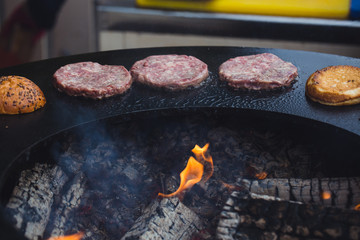 Preparing juicy burger cutlets on grill