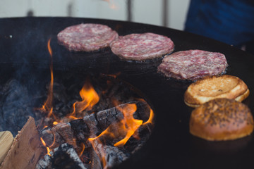 Preparing juicy burger cutlets on grill