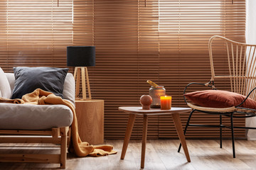 Stylish natural living room with raw wooden furniture and orange accents