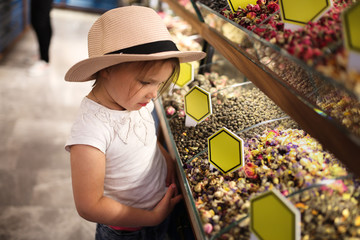 child in hat chooses oriental spices and tea
