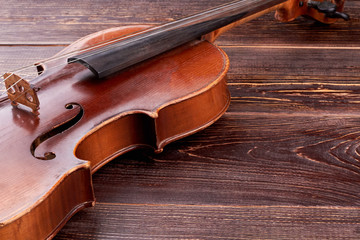 Fototapeta na wymiar Old-fashioned violin on wooden background. Aged cello and copy space. Baroque style instrument.