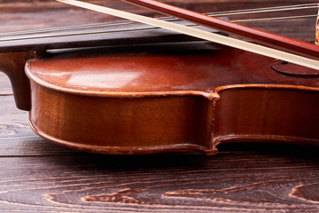 Detail of old brown violin. Vintage violin and fiddle stick close up. Equipment of classical music.