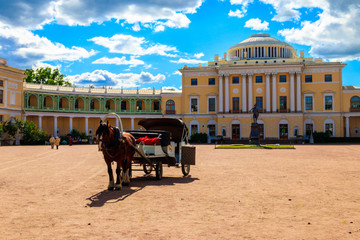 Fototapeta na wymiar Horse-drawn wagon on the square at the Pavlovsk Palace in Pavlovsk, Russia