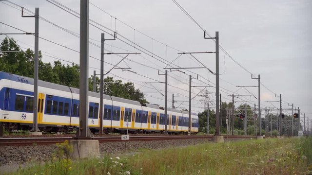 Dutch Sprinter train passes in high speed near Utrecht on a sunny day, Utrecht, The Netherlands, July 12th 2019
