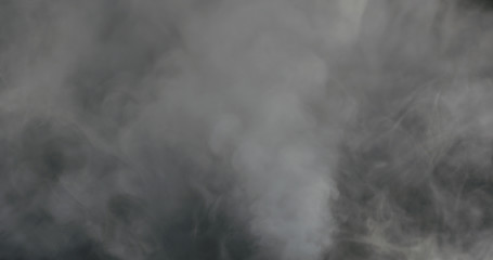 water vapor cloud comes from below over black background with motion blur