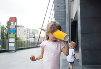 Little girl eating popcorn on the street.Childhood and leisure